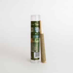 A 1g Hot Lava Sativa pre-roll by Top Shelf is placed next to its transparent container, both set against a plain white background.
