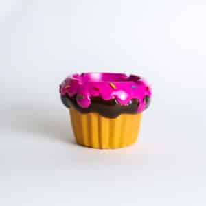 The Fujima 3.25" Cupcake Polystone Ashtray is a small, cupcake-shaped ashtray featuring a yellow base and pink frosted top with sprinkles.