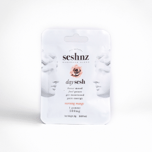 A white packet labeled “Morning Mango - SESHNZ Daytime Blend Mushroom Gummies - Single” features artistic face illustrations, a rose graphic, and details: 1 gummy, 500mg, morning mango flavor, 5g net weight.