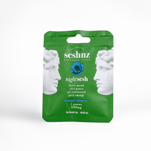 Green pouch labeled "Midnight Blueberry - SESHNZ Nighttime Blend Mushroom Gummies - Single," features two white statue faces, a blue rose, and product info for a 500mg gummy.